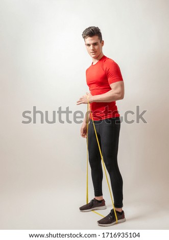 Young athlete isolated on white background stretches a sports elastic band