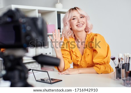 Pretty woman recording a video at home