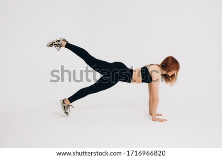 Girl trainer performs sports exercises. Sport trainer on isolated white background. Girl with a beautiful figure.