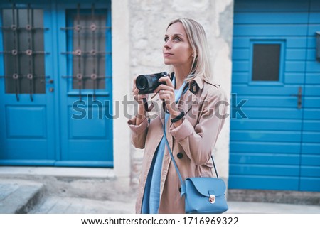 Tourism and technology. Happy young woman taking photo of old town. Traveling by Europe.