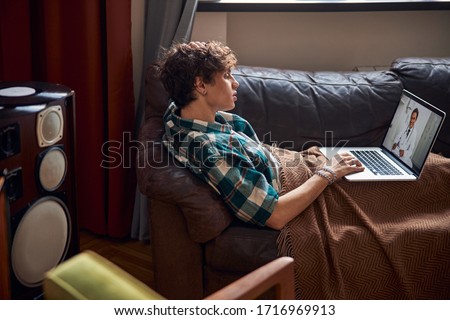 Attractive young man having online consultation with doctor at home stock photo