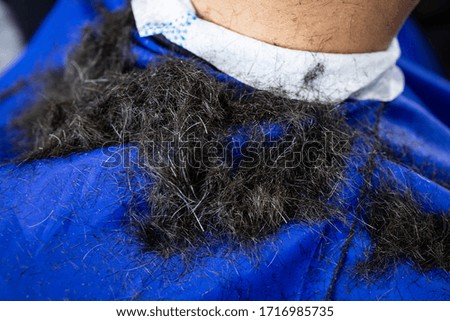 Hair on man's shoulders after haircut at barbershop
