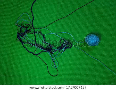 tangled threads and a blue ball of floss on a chromakey background