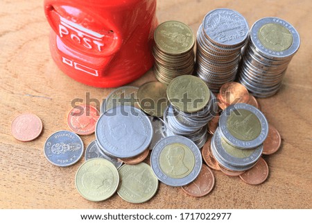 Close-up of many Thai baht coins on a wooden floor selective focus and shallow depth of field