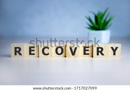 RECOVERY word concept written on wooden cubes lying on a light table and light background. Royalty-Free Stock Photo #1717027099