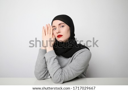 Young Muslim woman in hijab with red lips isolated on white background. Space for text.
