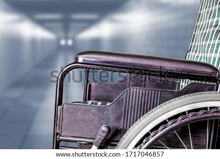 Empty wheelchair in hallway of hospital or retirement nursing care home with copy space. Concept of sickness, loneliness, neglect, isolation due to pandemics, outbreaks, epidemics, illness, lockdowns. Royalty-Free Stock Photo #1717046857