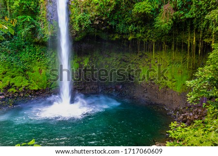 La Fortuna Waterfall in a forest, close to Arenal Volcano, Costa Rica national park. Central America. Royalty-Free Stock Photo #1717060609