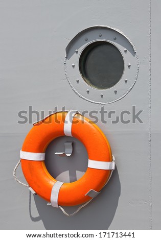 Life ring hangs on the boat wall for emergencies.