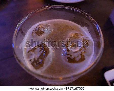 A glass of beer shot from the top corner, showing a thin beer bubble.