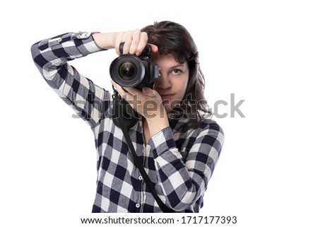 Young female art student holding a dslr camera and studying to be a professional or amateur photographer.  She looks creative and inspired to become a photo journalist