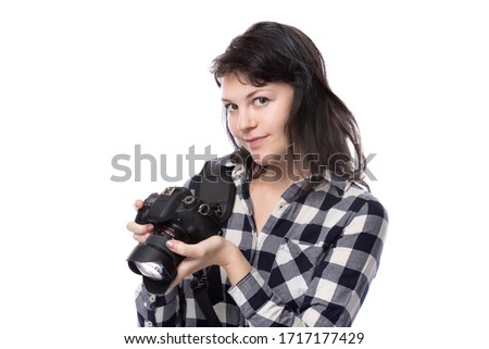 Young female art student holding a dslr camera and studying to be a professional or amateur photographer.  She looks creative and inspired to become a photo journalist