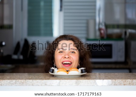 Funny picture of woman with Sushi at the kitchen. Fun, joke and humor concept.