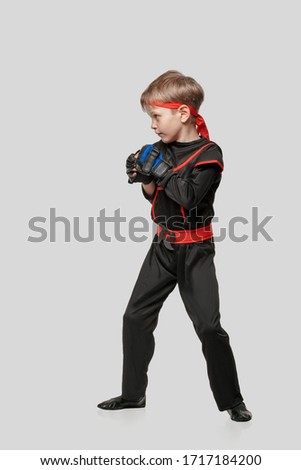 Young boy training karate martial art isolated on light gray background
