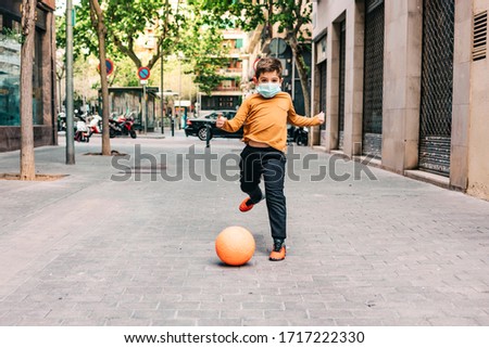 Little boy playing football with a mask