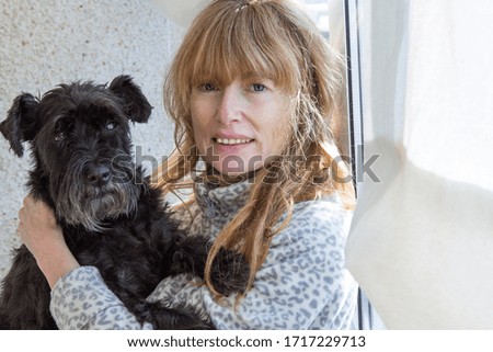blonde woman with dog looking out the window