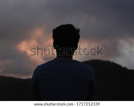 man hiding in dark revealed in silhouette