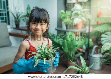 happy asian kid planting and gardening activity at home by herself