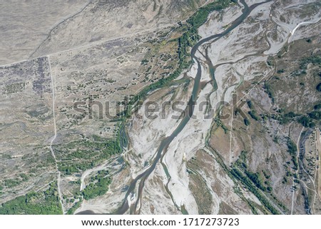 aerial, from a glider, of Pukaki riverbed with curlicues of shoals in barren country, shot in bright spring light from above, Canterbury, South Island, New Zealand

