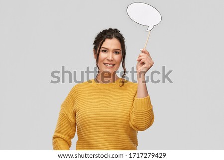 photo booth, communication and people concept - portrait of happy smiling young woman with pierced nose holding blank speech bubble party accessory over grey background Royalty-Free Stock Photo #1717279429