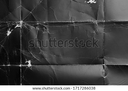 Crumpled black paper with wrinkles and rubbed corners. Old wrapping dusty cardboard. Abstract dramatic background. For design and titles.