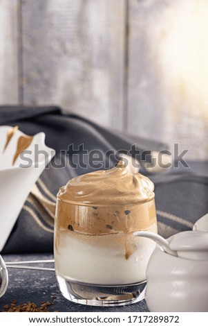 vertical closeup dalgona coffee on grey kitchen table, korean drinks concept