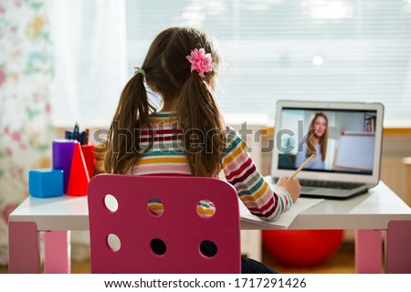 Young female distance teacher having video conference call with pupil using webcam. Online education and e-learning concept. Home quarantine distance learning and working from home. Royalty-Free Stock Photo #1717291426
