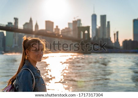 Girl enjoying magical sunset from the ferry  passing under the Brooklyn bridge