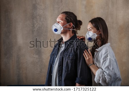 Couple in love, man and woman in protective medical mask on face at home. Environmental pollution concept. Guy, girl against Chinese pandemic coronavirus