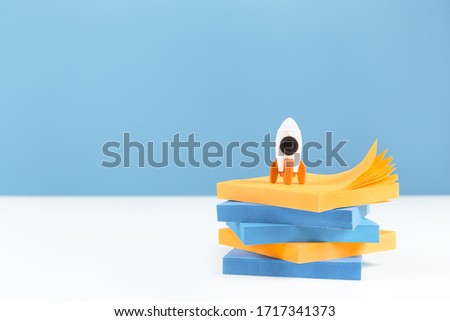 Business or education growth development and success concept banner. Rocket and laptop on white office or home desk with blue background. Innovative thinking. Copy space