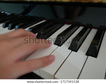 one hand on piano keys. first person view.