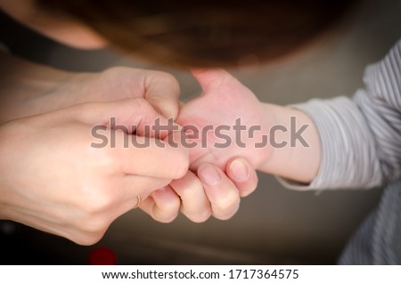A splinter in the hand of a child. Girl pulls a splinter from the hands of a child. Royalty-Free Stock Photo #1717364575
