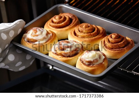 Fresh bakery. Cinnamon rolls are oiled. Homemade cinnabon. Royalty-Free Stock Photo #1717373386