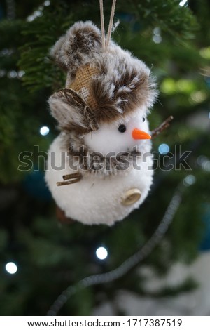 
Christmas decoration. hanging on a christmas tree. garland bulbs are out of focus and beautifully decorate the picture. snowman. selective focus. blurred