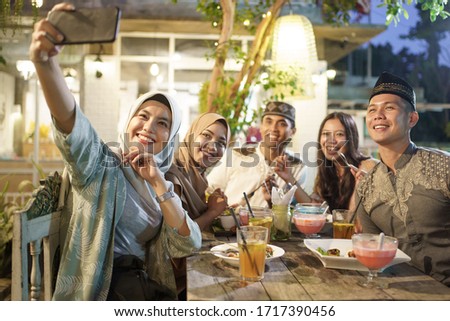breaking the fast. muslim friend take selfie together during iftar dinner on ramadhan