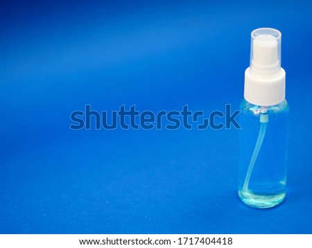 A picture of a blue alcohol bottle isolate on a blue background  Used for disinfection during the outbreak of the covid-19 virus.