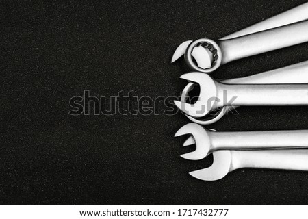 Group chrome plated wrench. Isolated on a black relief background.