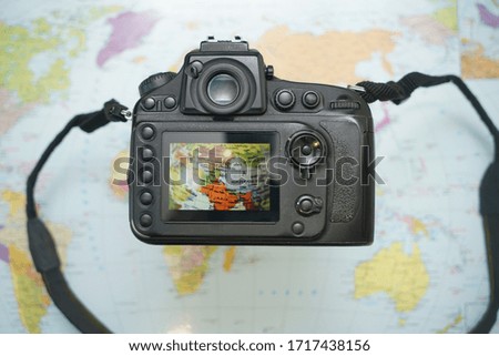 image of world map  on screen professional photo camera. Top view.  traveling life concept. 
