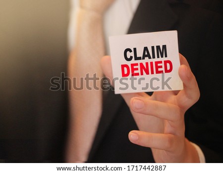 Claim Denied words on a card in hand of businessman. Business agreement termination or sponsorship project refuce concept.