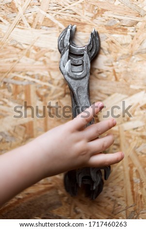 Spanners. A set of tools for repairing a wrench. Set of wrenches of different sizes and diameters on a brown wooden background. a small child reaches for wrenches. flat lay