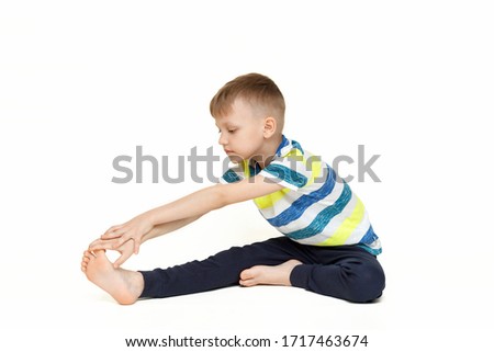 The child does gymnastic exercises for muscle stretching. Gymnastics at home during a pandemic. The boy goes in for sports Isolated on a white background.