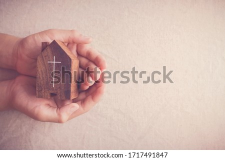Child hands holding church, serving God, praying hands, home church community, worship together at home, streaming online church service,   Mission of gospel, social distancing concept Royalty-Free Stock Photo #1717491847