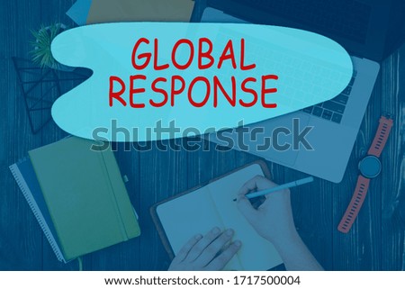 Wooden table with laptop, watch, few notebooks, pencils. Workspace background top view with text Global response
