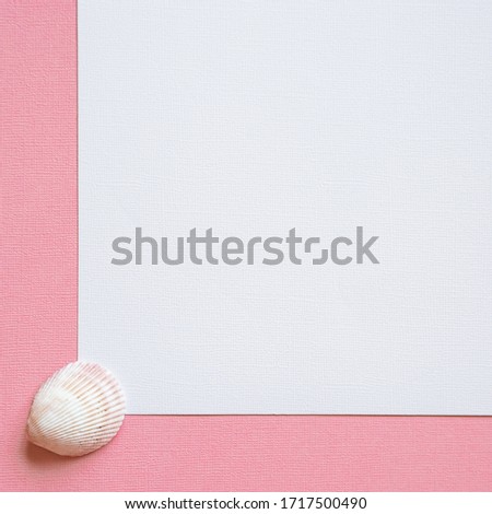 Pink pastel background with place for text on white paper. Flat lay in marine style with seashells and pearls. Main trend concept. Natural and authentic  mood. Perfect for backdrop for your design.