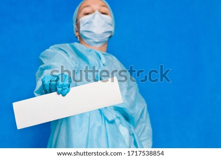 Young doctor showing white blank paper for writing any information.