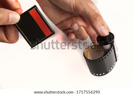 35mm film and compact flash memory card, held in hand on white background. Present and past