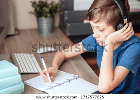 A teenage boy does homework, learns using a computer. Distance learning online. A child in quarantine in isolation learns independently at home.