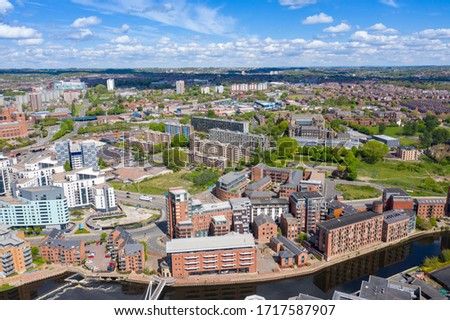 Aerial footage of the Leeds city centre showing the area called The Leeds Dock, along side the Leeds and Liverpool canal showing apartments and businesses along side the canal on a blue sky sunny day