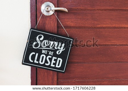 Sorry we're closed sign. grunge image hanging on cafe wooden door.