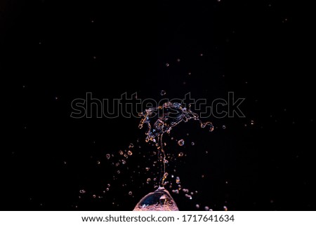 Macro photograph of water with bright colors dripping and splashing